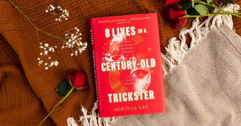 8 lIves of a Century-Old Trickster Flat Lay with Roses and Blanket